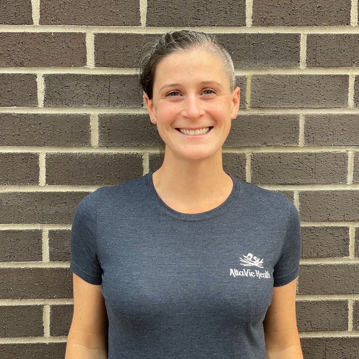 A practitioner at AltaVie Health, in a clinic shirt outside the Cedar Avenue office
